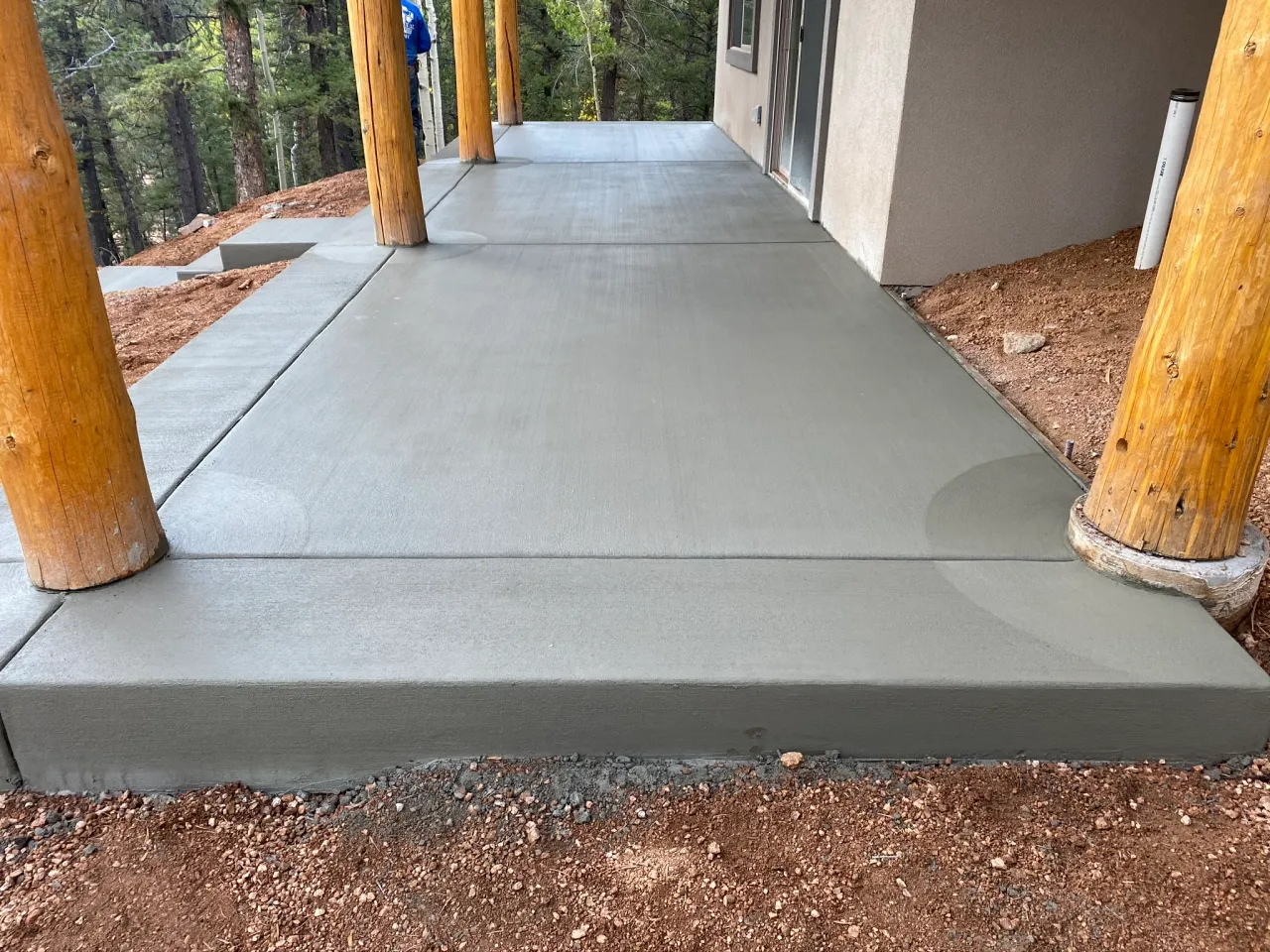 Smooth finished concrete porch and walkway with log posts at a mountain home near Monument, CO