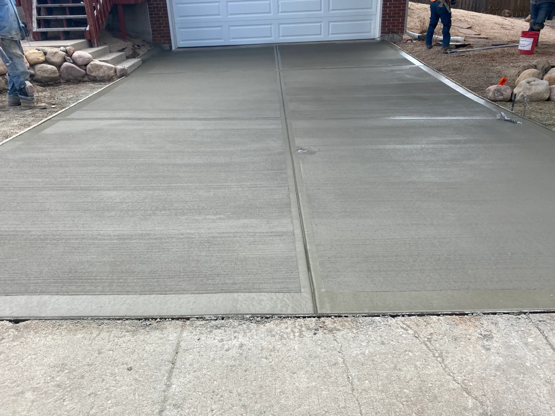 Two-car concrete driveway with broom finish leading to a garage door in Colorado Springs, CO