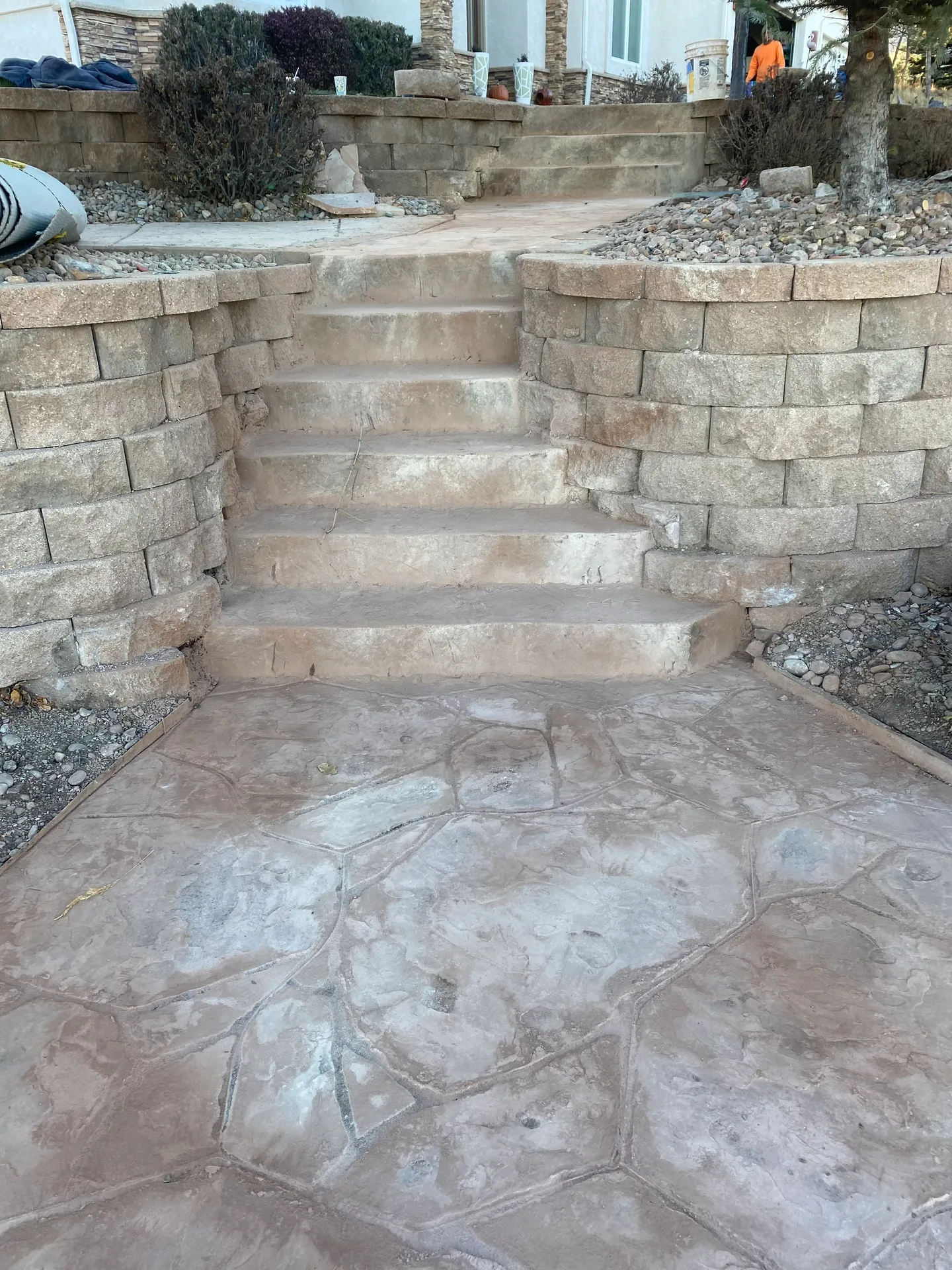 Tan flagstone-pattern stamped concrete walkway and steps between block retaining walls in Colorado Springs, CO
