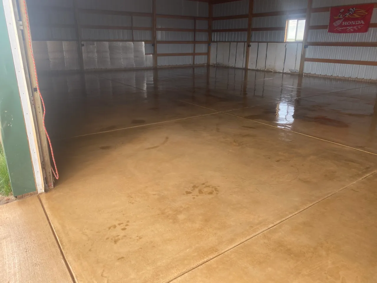 Acid-stained and sealed decorative concrete shop floor with a golden finish in Calhan, CO