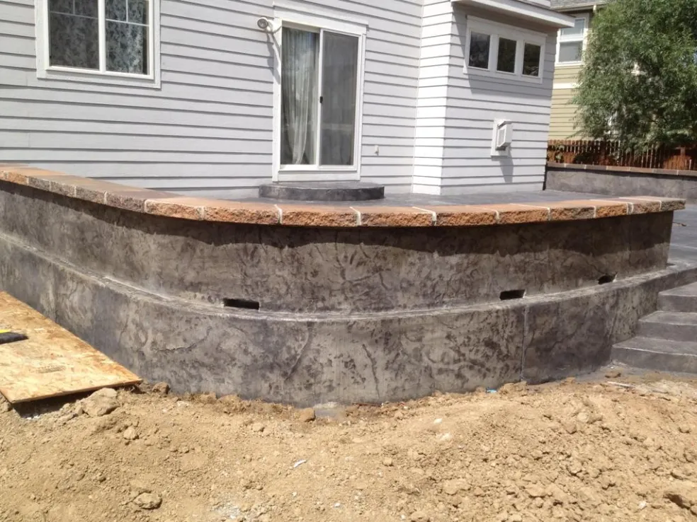 Stamped concrete raised patio with seat wall and flagstone cap in Colorado Springs, CO