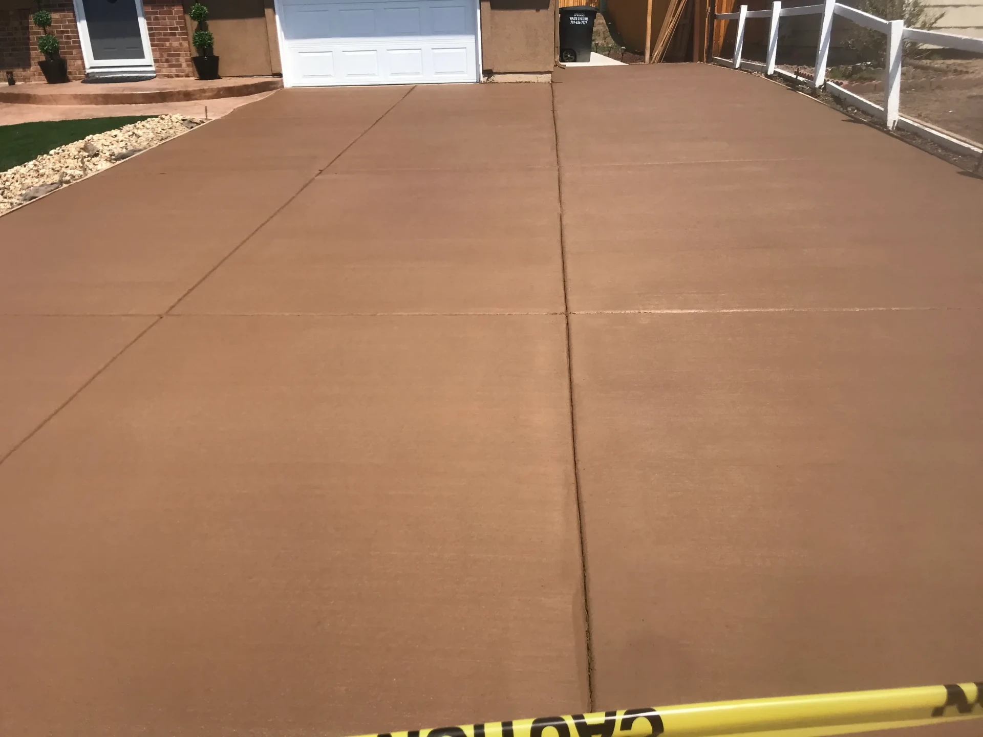 Wide tan colored concrete driveway with clean control joints at a Peyton, CO home