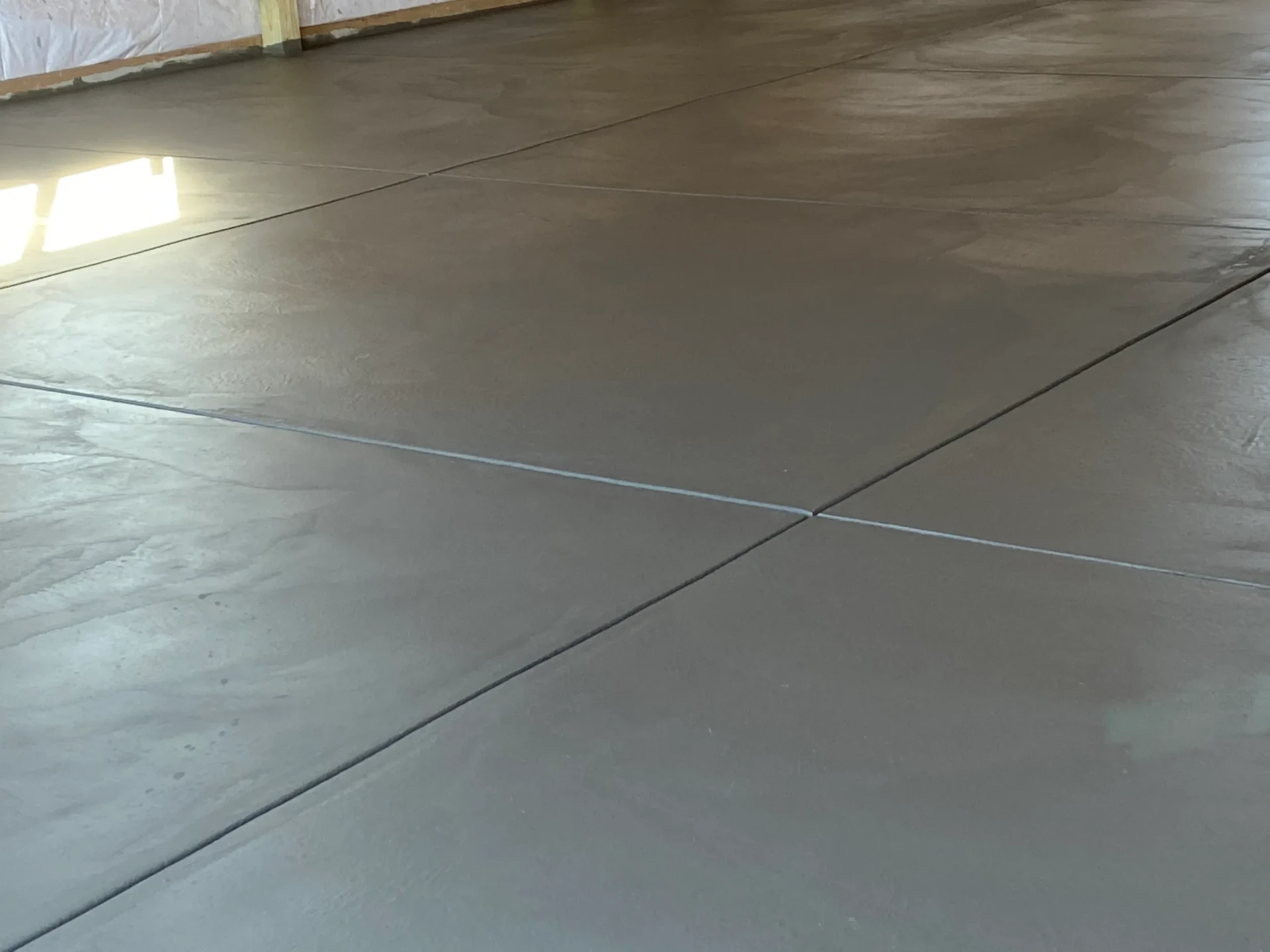 Smooth troweled interior concrete garage floor with saw-cut joints in Fountain, CO
