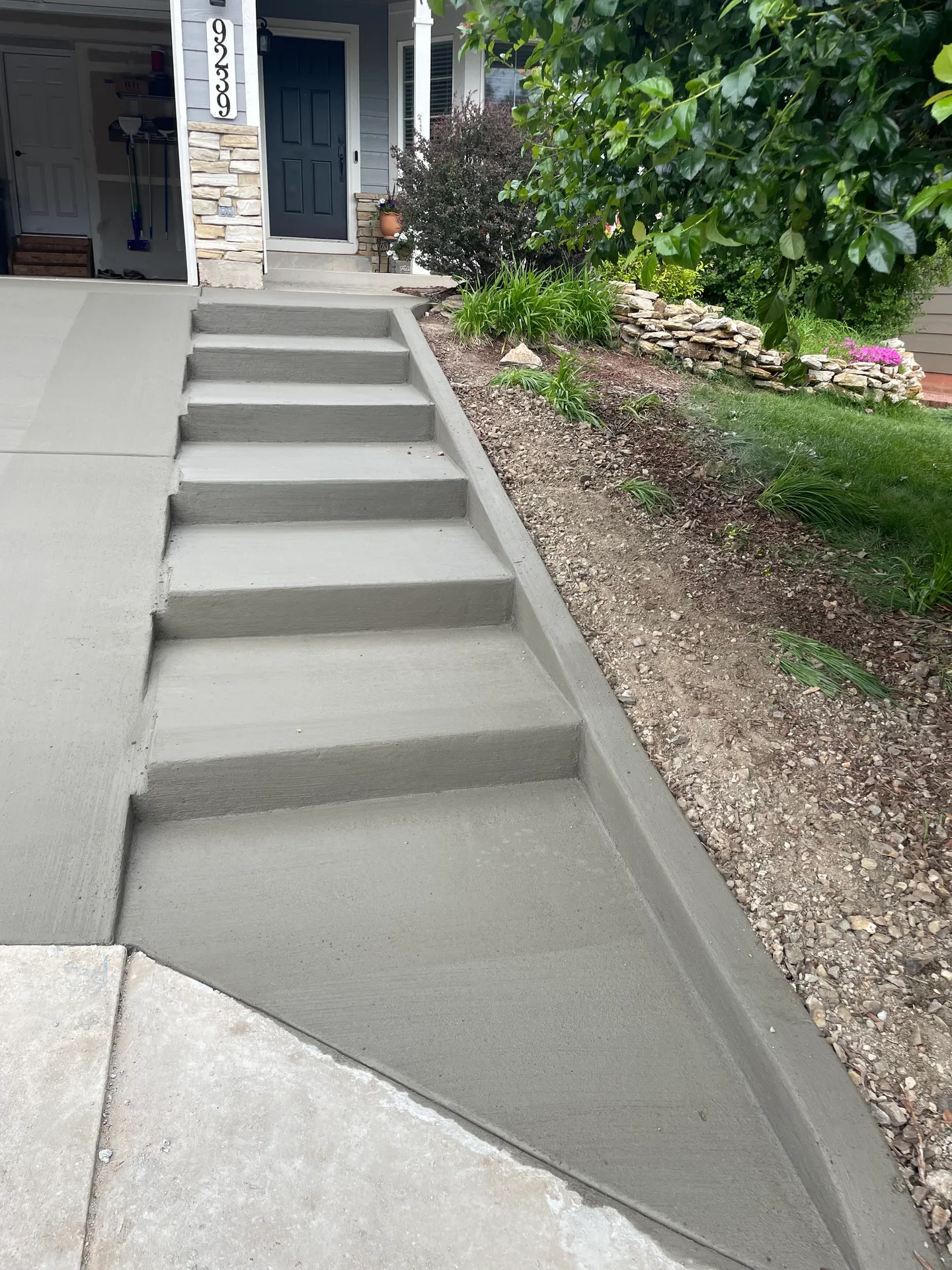 Concrete front entry steps and walkway beside landscaping at a Falcon, CO home