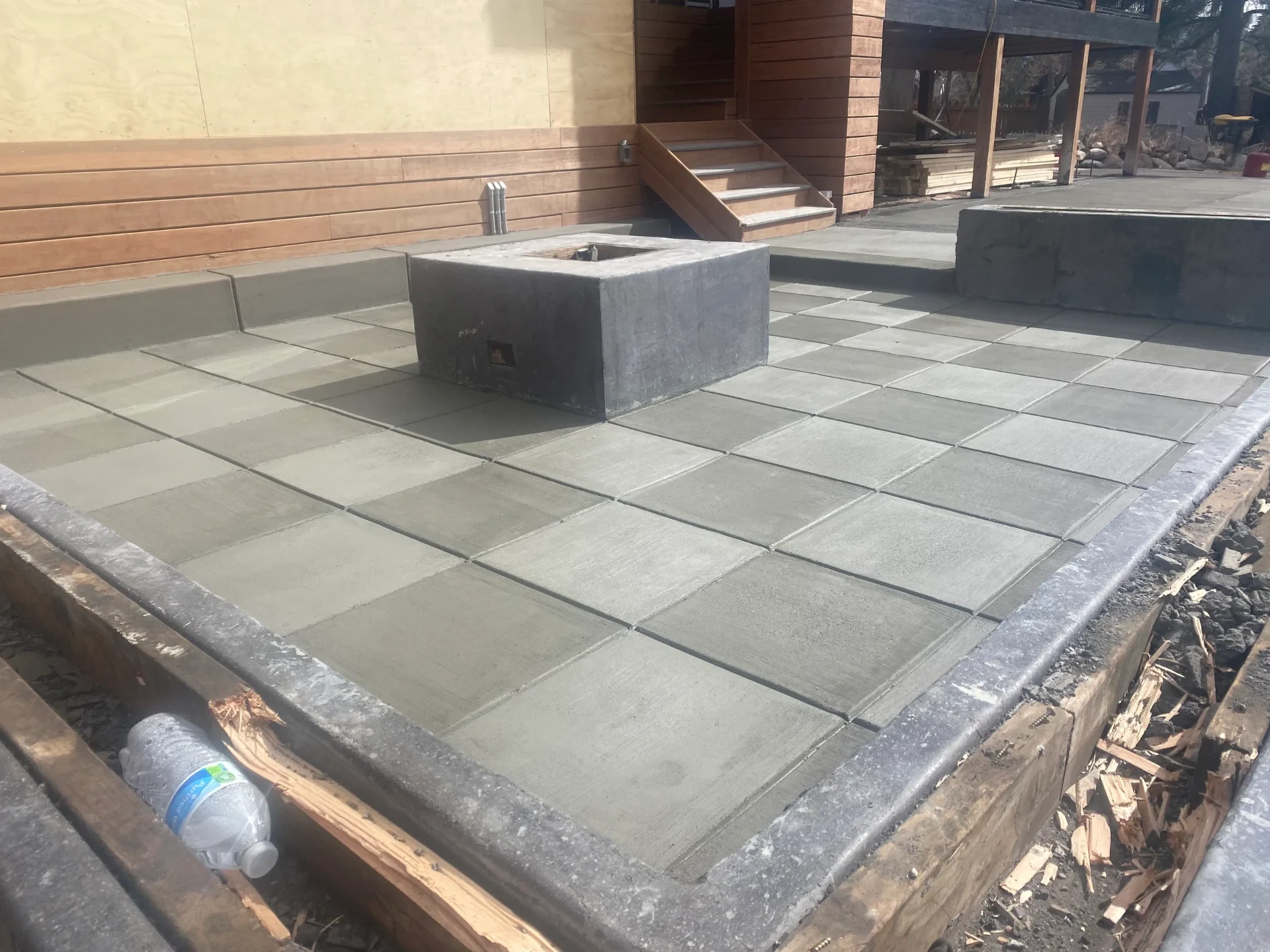 Saw-cut grid pattern concrete patio with a square concrete fire pit at a new build in El Paso County, CO